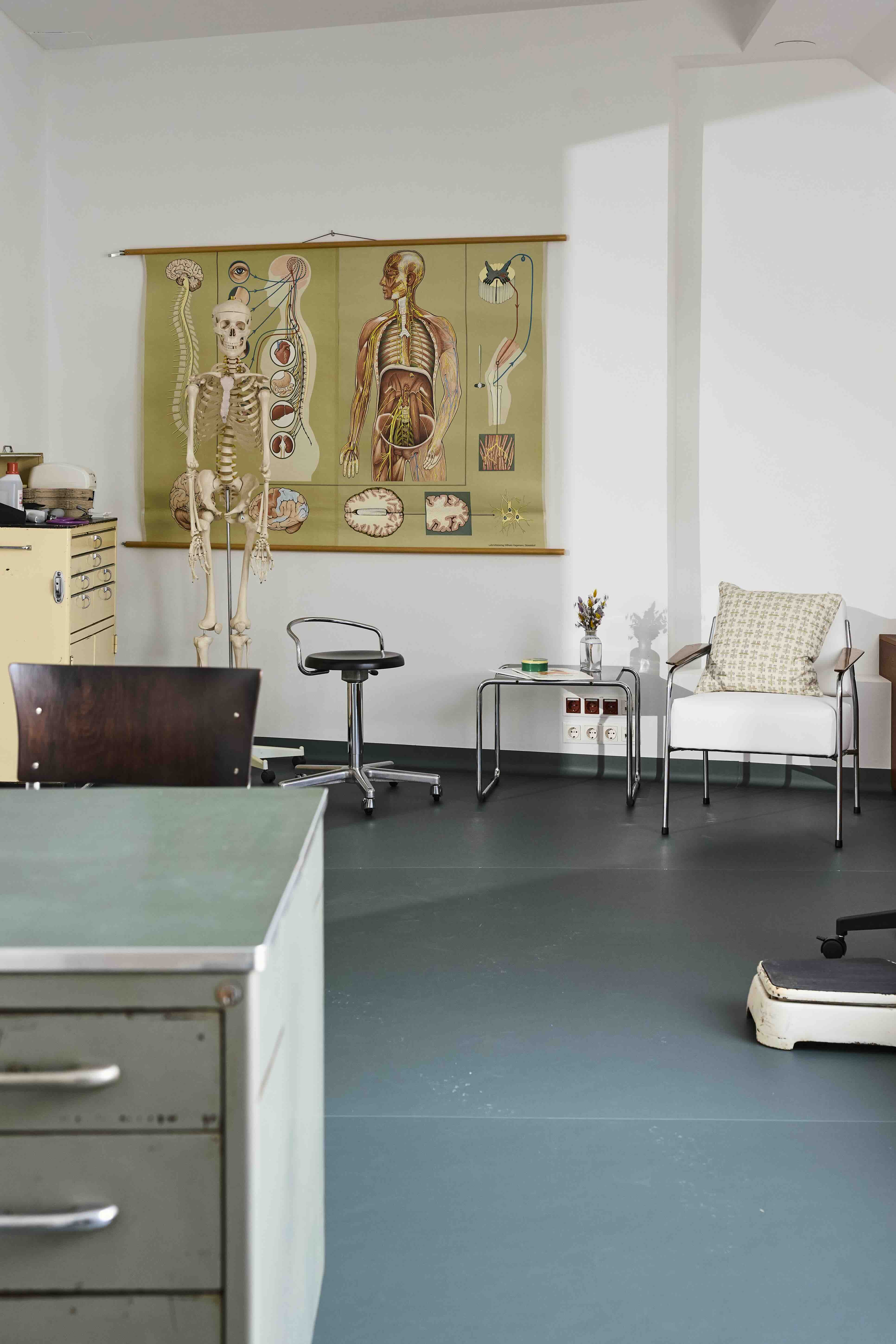 Untersuchungszimmer der Ordination mit anatomischer Lehrtafel